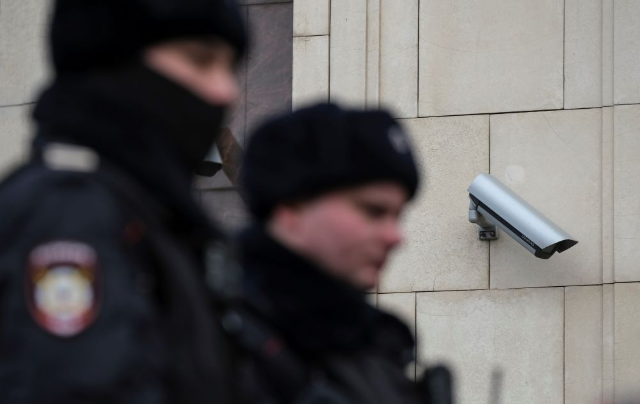 Police officers walk past a surveillance camera in central Moscow, Russia January 26, 2020